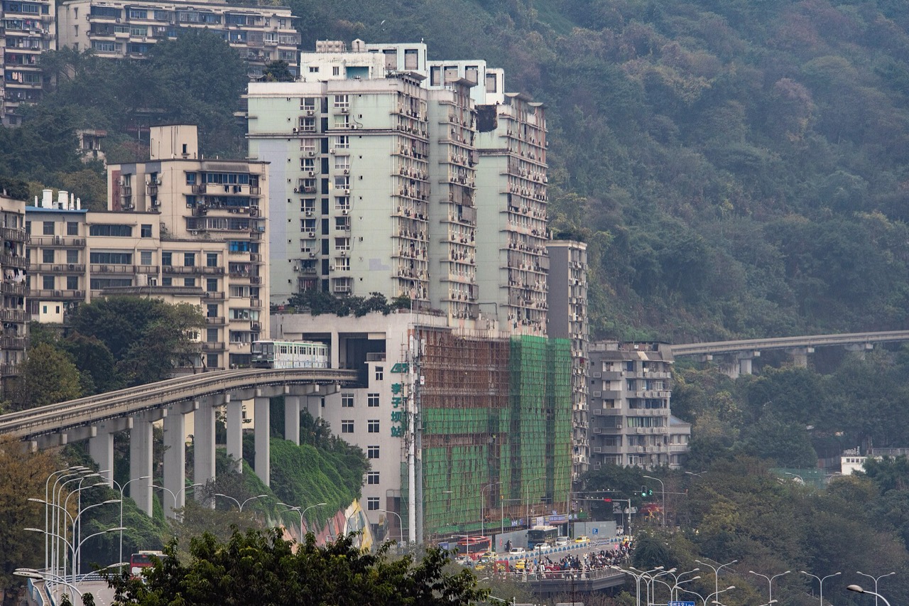 A monorail train emerging from the residential tower at Liziba station, Chongqing