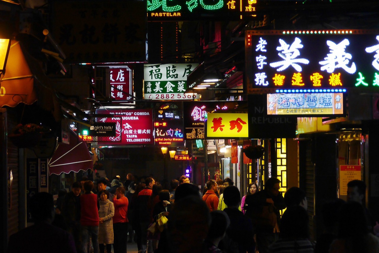 Rua do Cunha, Taipa Village at night — neon shop signs over the food street