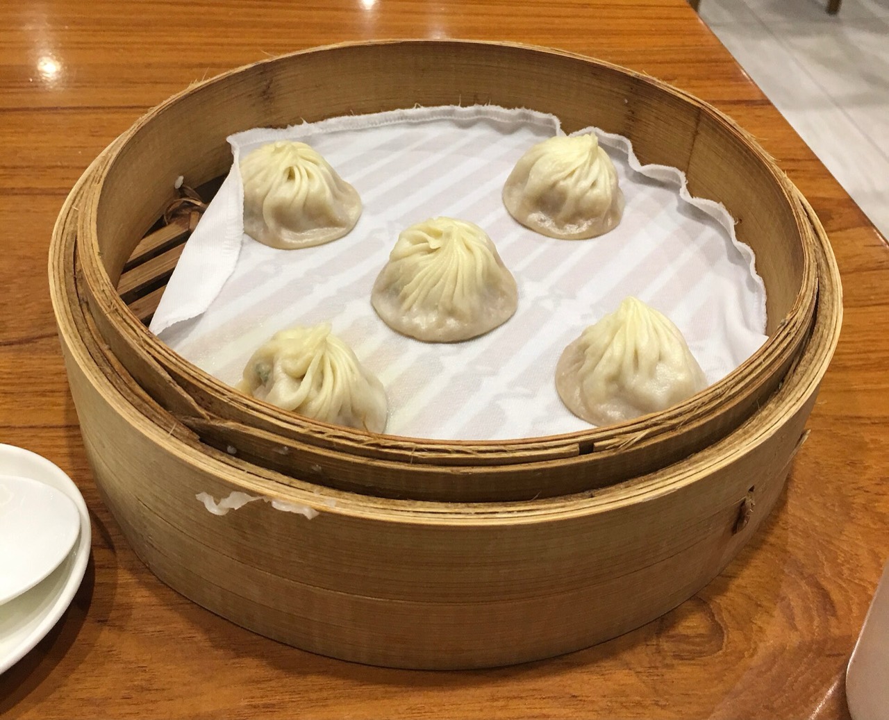A steamer basket of xiaolongbao soup dumplings